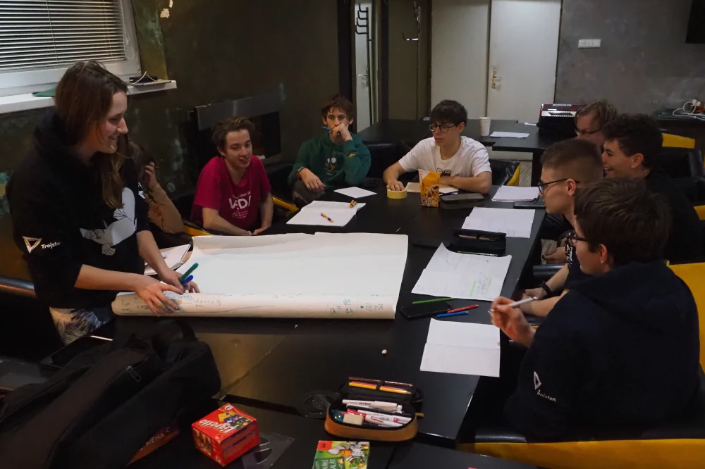 Účastníci sústredenia FKS sedia počas prednášky pri stole